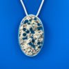 Oval white and gray speckled granite pendant with blue azurite dots throughout