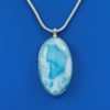Oval larimar stone pendant with shades of light blue set in silver on a silver necklace chain